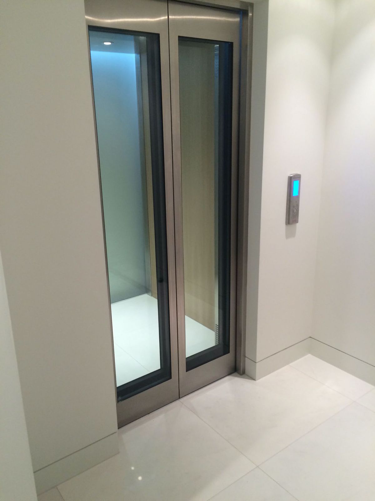 Glass home lift beside stairs