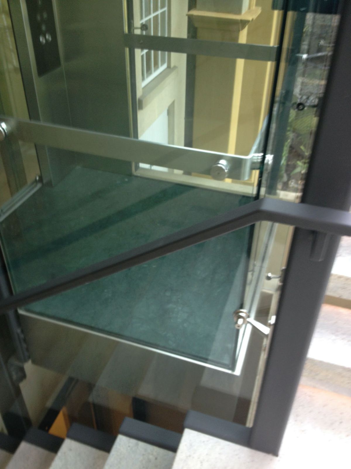 Glass home lift over a staircase