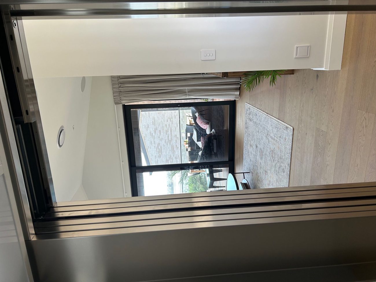 Glass Phoenix Home Lift beside a staircase